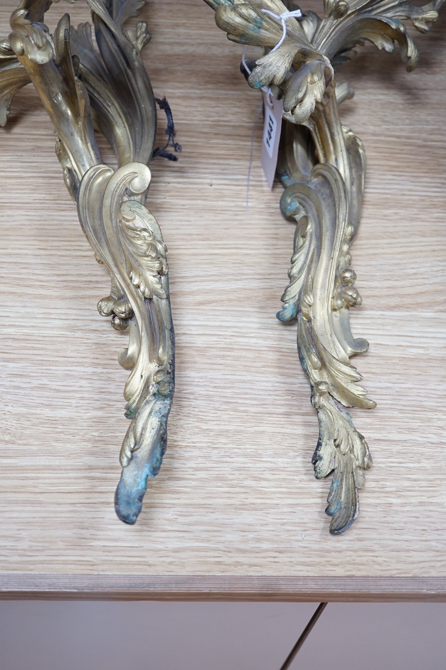 A pair of rococo style ormolu two branch wall lights, 76cm